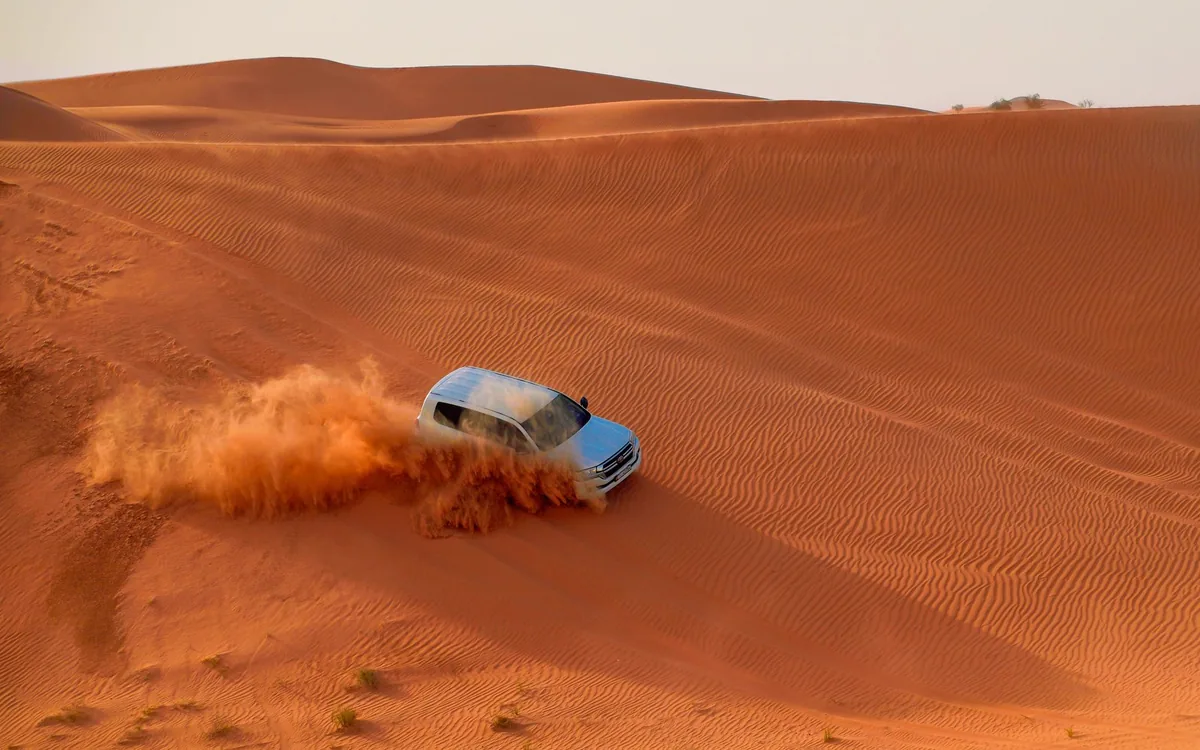 A helicopter over the desert dunes outside Dubai