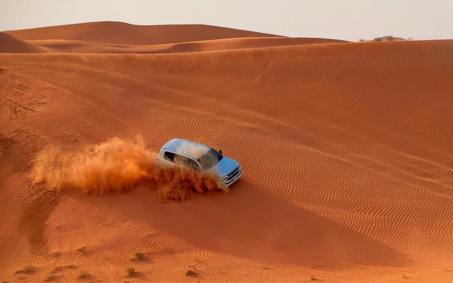 A helicopter over the desert dunes outside Dubai